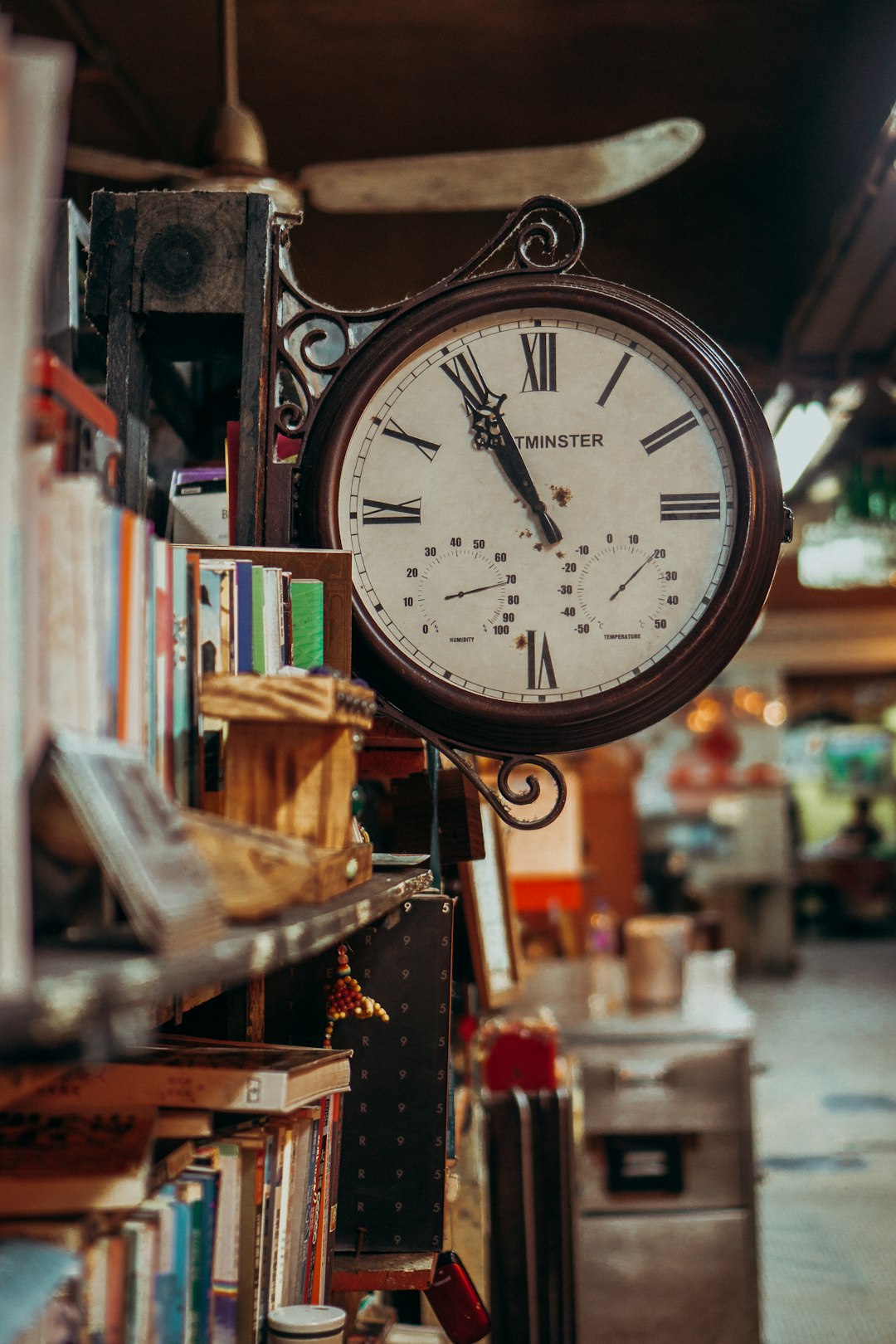Antique clock hanging above a bookshelf