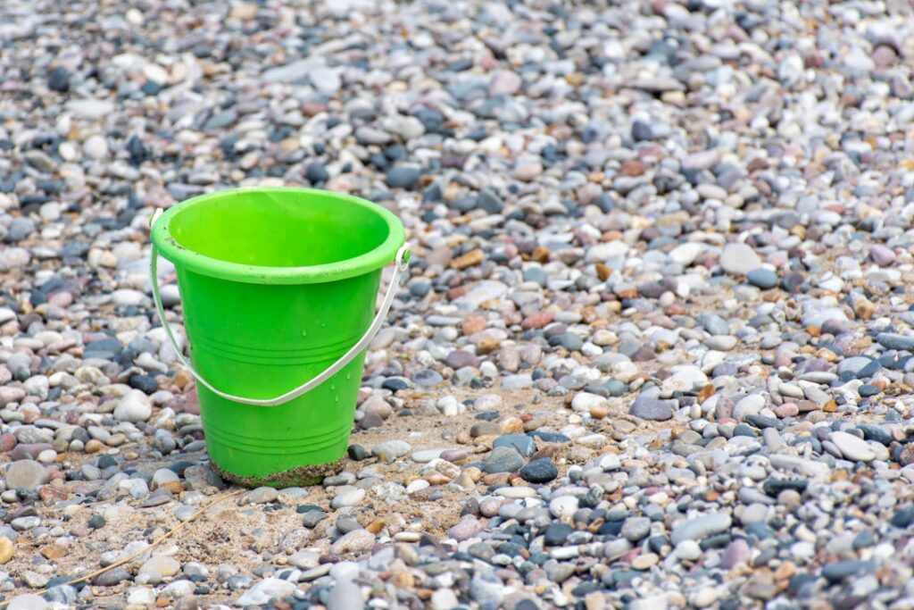 green plastic bucket on stones