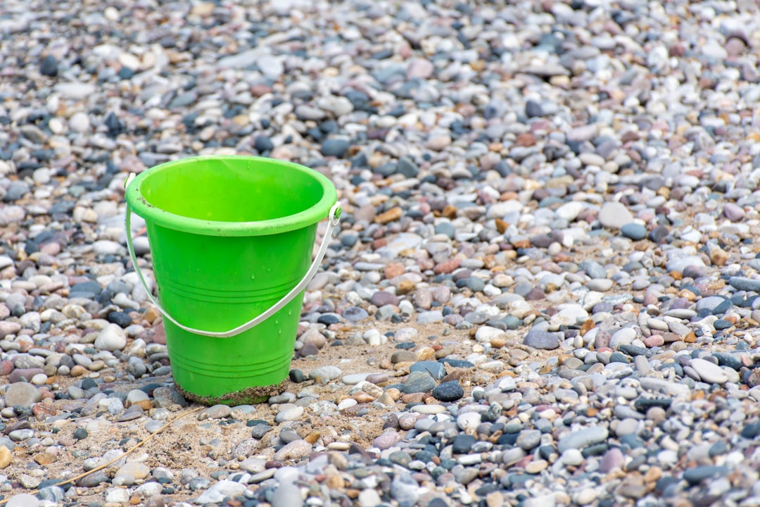 green plastic bucket on stones