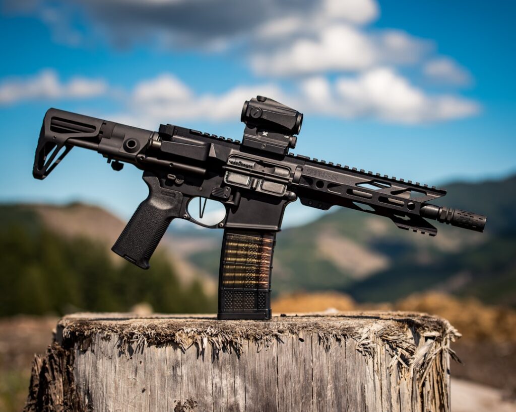 black assault rifle on brown wooden log