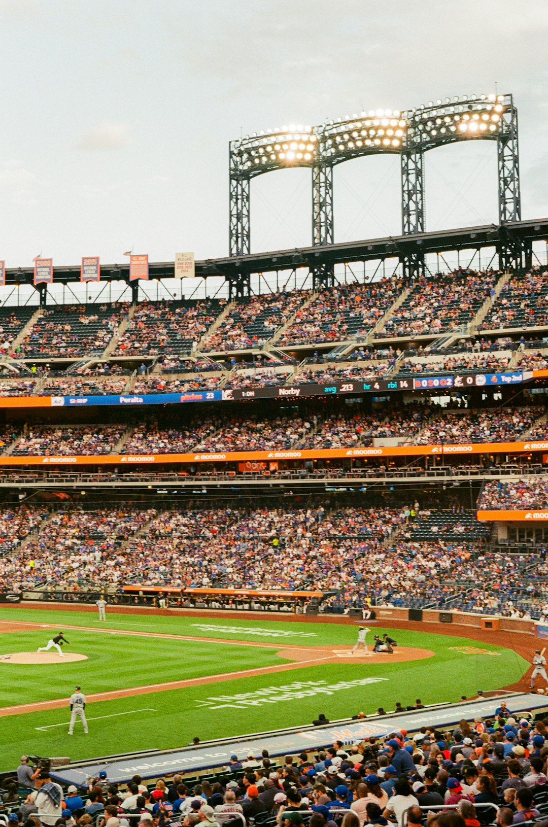 A baseball game in a crowded stadium under bright lights